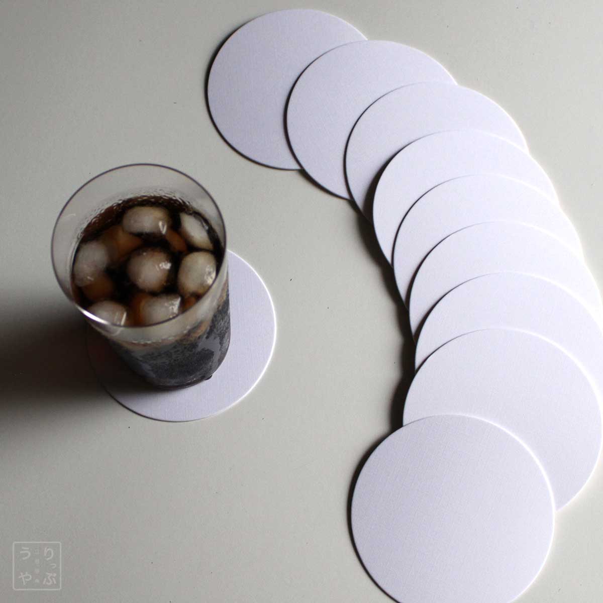 紙製コースター 白 丸 9cm径 1mm厚 10枚とグラス 斜め上から